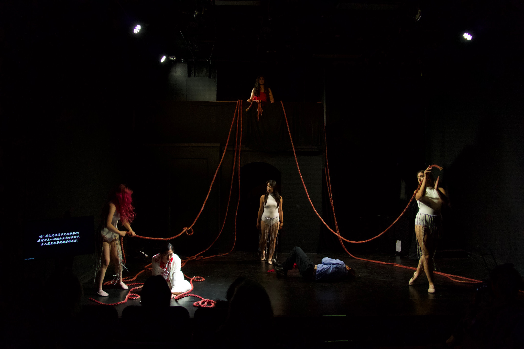 Her Rage performers with ropes across a dark stage