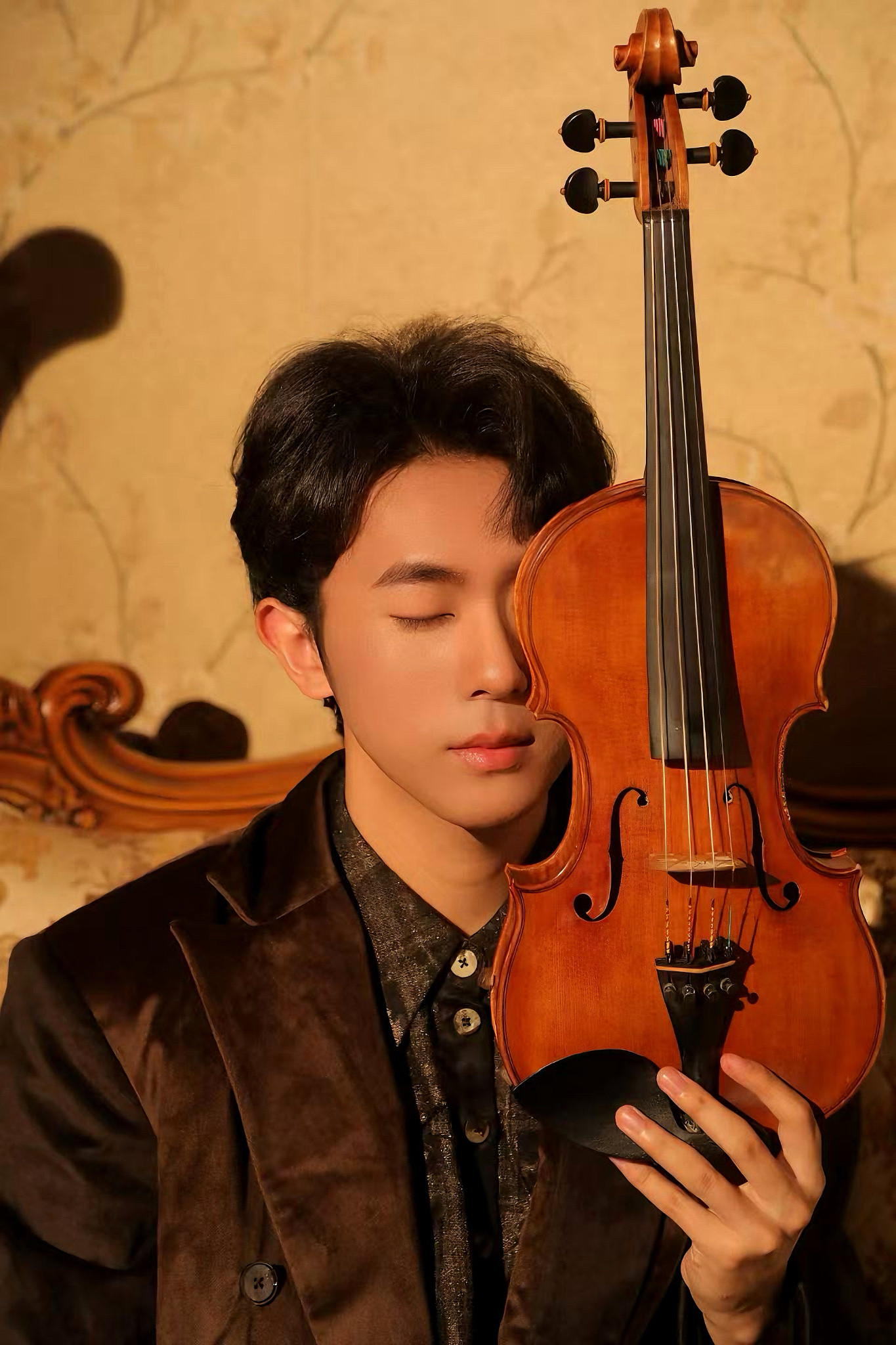 Tian Li holding a violin in warm light