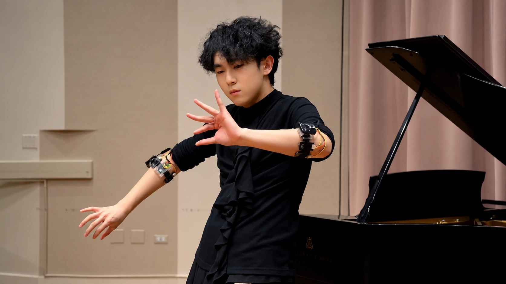 Performer wearing sensors beside a grand piano