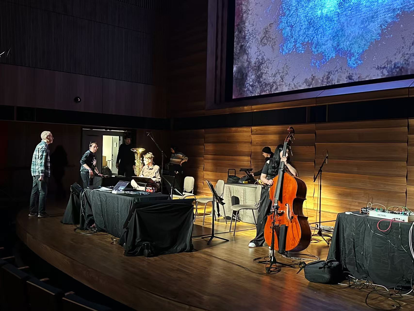SuperCollider Symposium stage with musicians, instruments and projected visuals