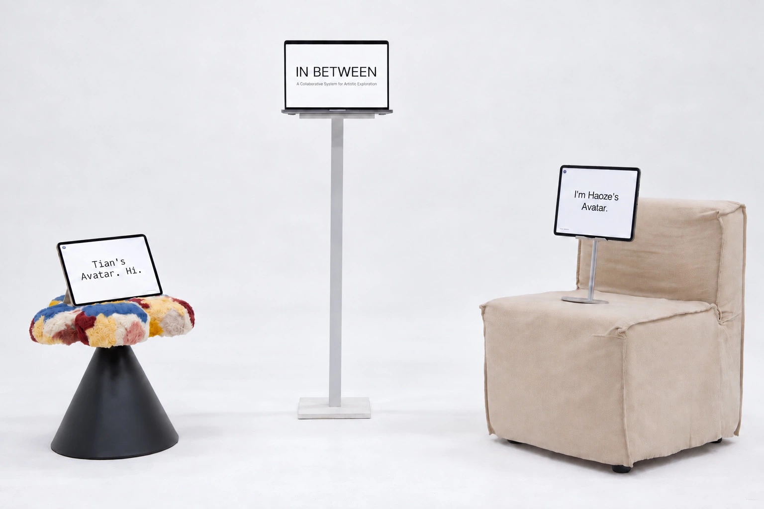 Three screens arranged with two seats: a central IN BETWEEN display and two avatar tablets
